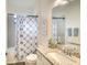 Well-lit bathroom featuring a shower-tub combo with a decorative curtain, granite countertop and neutral paint at 5433 Mystic Water Cv, Lakewood Ranch, FL 34211