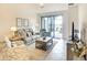 Comfortable living room featuring neutral paint, modern furniture, tile flooring, and access to the outdoor patio at 5433 Mystic Water Cv, Lakewood Ranch, FL 34211