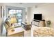 Stylish living room features an entertainment center, neutral furniture, tile flooring, and a sliding door leading to the patio at 5433 Mystic Water Cv, Lakewood Ranch, FL 34211