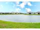 Scenic pond view with several homes in the background on a sunny day with blue skies at 5433 Mystic Water Cv, Lakewood Ranch, FL 34211
