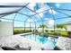 Relaxing screened pool features a brick deck and water feature with a view of the lake at 5433 Mystic Water Cv, Lakewood Ranch, FL 34211
