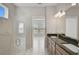 Bathroom featuring a glass shower, double sinks with granite, and bright lighting at 5675 Equator Ct, Nokomis, FL 34275
