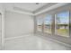 Bright bedroom features three large windows with views and marble tile flooring at 5675 Equator Ct, Nokomis, FL 34275