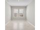 Empty room with marble tile flooring, natural light and neutral color scheme at 5675 Equator Ct, Nokomis, FL 34275