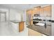 Well-lit kitchen featuring stainless steel appliances, a farmhouse sink, and spacious granite countertops at 5675 Equator Ct, Nokomis, FL 34275