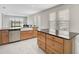 Kitchen with granite countertops, a farmhouse sink, stainless steel appliances, and a view to the living room at 5675 Equator Ct, Nokomis, FL 34275