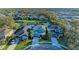 An aerial view of a neighborhood featuring houses with landscaped yards and a pond at 5709 Sunflower Cir, Sarasota, FL 34238