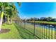 Beautiful backyard with a black metal fence, green grass, and a scenic water view, creating a peaceful retreat at 5709 Sunflower Cir, Sarasota, FL 34238