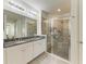 Well-lit bathroom with double sinks, a large mirror, and a modern glass-enclosed shower with seating at 5709 Sunflower Cir, Sarasota, FL 34238
