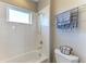This bathroom features a tiled shower and tub with a window, next to a toilet with towel rack at 5709 Sunflower Cir, Sarasota, FL 34238