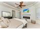 Relaxing bedroom featuring an electric fireplace with mounted TV, shiplap wall, and bright windows at 5709 Sunflower Cir, Sarasota, FL 34238