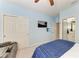 Blue bedroom with a TV, closet, and an open ensuite bathroom view at 5709 Sunflower Cir, Sarasota, FL 34238