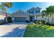 Two-story home with a gray facade, well-manicured lawn, and a two-car garage at 5709 Sunflower Cir, Sarasota, FL 34238