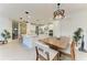 Bright, open kitchen with stainless steel appliances, a large island and wooden dining table with modern light fixtures at 5709 Sunflower Cir, Sarasota, FL 34238