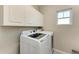 Laundry room with a front load washer and dryer plus upper cabinets at 5709 Sunflower Cir, Sarasota, FL 34238