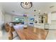 Open-concept living area with a large wooden table, a comfortable seating area and access to the outdoor space at 5709 Sunflower Cir, Sarasota, FL 34238
