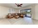 Spacious living room with leather seating, a ceiling fan, and a view of the outdoor patio and pool area at 5709 Sunflower Cir, Sarasota, FL 34238