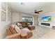 Inviting living room featuring a leather sectional sofa, a fireplace with a mounted TV, and serene outdoor views at 5709 Sunflower Cir, Sarasota, FL 34238
