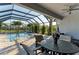 Enclosed pool area with a dining set, ceiling fan, and lush landscaping for a perfect outdoor living experience at 5709 Sunflower Cir, Sarasota, FL 34238