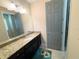 Well-lit bathroom featuring granite countertops, dark cabinetry, and a large mirror over the sink at 5746 Hydrangea Cir, Sarasota, FL 34238