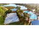 Serene community pool with an adjacent sand volleyball court, surrounded by palm trees and lush landscaping near a lake at 5746 Hydrangea Cir, Sarasota, FL 34238