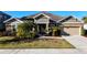 Beautiful one-story home featuring a lush lawn, tropical landscaping, and an attached garage at 5746 Hydrangea Cir, Sarasota, FL 34238