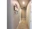 Hallway with neutral walls, tile floors, and picture frames on the wall at 5746 Hydrangea Cir, Sarasota, FL 34238