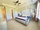 Spacious primary bedroom with a four-poster bed, walk-in closet, and ensuite bathroom at 5746 Hydrangea Cir, Sarasota, FL 34238