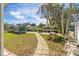 Manicured lawn leading to the lake, a picnic table, and lounging chairs offer ideal outdoor relaxation at 6201 Waverly Rd, Weeki Wachee, FL 34607