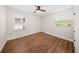 Comfortable bedroom with hardwood floors, natural light from windows and ceiling fan at 6201 Waverly Rd, Weeki Wachee, FL 34607