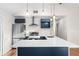 Open kitchen with stainless steel appliances, quartz countertops, and stylish blue cabinetry at 6201 Waverly Rd, Weeki Wachee, FL 34607
