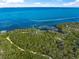 Scenic real estate aerial view showing the home's access to a trail through preserved land near the ocean at 691 Gulf Bay Rd, Longboat Key, FL 34228