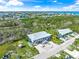 An aerial view shows the property with a gray roof, lush greenery, and surrounding neighborhood near the water at 691 Gulf Bay Rd, Longboat Key, FL 34228