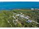 Stunning aerial view of a waterfront property surrounded by lush greenery, boasting beautiful bay views and serene privacy at 691 Gulf Bay Rd, Longboat Key, FL 34228