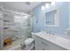 Updated bathroom featuring blue walls, glass shower with bench seat and a carrara marble vanity at 691 Gulf Bay Rd, Longboat Key, FL 34228