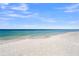 Wide sandy beach featuring a clear blue ocean and sky, perfect for relaxation and recreation at 691 Gulf Bay Rd, Longboat Key, FL 34228