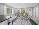 Dining area features modern furniture, natural light, and an adjacent kitchen counter at 691 Gulf Bay Rd, Longboat Key, FL 34228