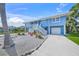 Charming two-story home featuring a garage, a front porch, and stairs, with a well-maintained yard at 691 Gulf Bay Rd, Longboat Key, FL 34228
