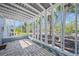 Covered patio area with brick flooring, offering an outdoor space with views of the yard and trees at 691 Gulf Bay Rd, Longboat Key, FL 34228