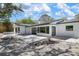 Backyard patio with light colored gravel and sliders to the modern, renovated interior at 7345 Pine Needle Rd, Sarasota, FL 34242