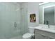 Modern bathroom with a glass-enclosed shower, toilet, vanity, sink, and lighted mirror at 7744 Sandhill Lake Dr, Sarasota, FL 34241