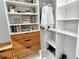 Closet with white shelving, wooden drawers and hanging storage with books, decoratives and clothing at 7744 Sandhill Lake Dr, Sarasota, FL 34241