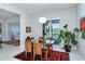 Bright dining room with glass-top table, modern light fixture and a view of the outdoor pool at 7744 Sandhill Lake Dr, Sarasota, FL 34241