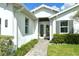 Inviting entrance to a home featuring a well-kept garden and a stone pathway leading to double glass doors at 7744 Sandhill Lake Dr, Sarasota, FL 34241