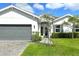 Close up view of a beautiful one-story house with well-maintained lawn and a gray-colored garage door at 7744 Sandhill Lake Dr, Sarasota, FL 34241