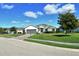 Charming single-story home with a well-manicured lawn and inviting curb appeal under a beautiful blue sky at 7744 Sandhill Lake Dr, Sarasota, FL 34241
