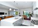 Open-concept kitchen with stainless steel appliances, island, and seamless connection to living and dining areas at 7744 Sandhill Lake Dr, Sarasota, FL 34241