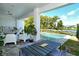 Inviting outdoor patio featuring a seating area, dining table, and a refreshing pool surrounded by lush greenery at 7744 Sandhill Lake Dr, Sarasota, FL 34241