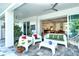 Relaxing covered patio area with stylish white outdoor furniture, ceiling fans and view of the interior at 7744 Sandhill Lake Dr, Sarasota, FL 34241