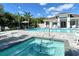 Community pool and hot tub area with lounge chairs and umbrellas at 7744 Sandhill Lake Dr, Sarasota, FL 34241